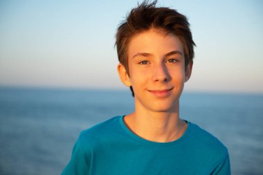 Plajdaki yakışıklı genç çocuk. Akdeniz kıyısında gülümseyen güzel bir genç çocuk. Seyahat, yaz tatili, turizm, gençlik yaşam tarzı.