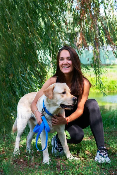 Jovem Mulher Bonita Alegre Sentado Abraçando Seu Cão Margem Rio — Fotografia de Stock