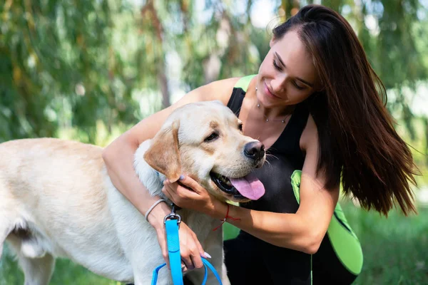 Fröhliche Hübsche Junge Frau Sitzt Und Umarmt Ihren Hund Flussufer — Stockfoto