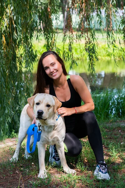 Vrolijke Mooie Jonge Vrouw Zitten Knuffelen Haar Hond Aan Oever — Stockfoto