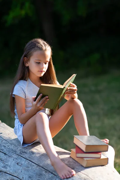 Charming Little Girl Long Brown Hair Reads Book Outdoor Sitting —  Fotos de Stock