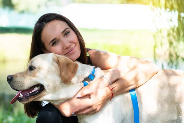 Fröhliche Hübsche Junge Frau Sitzt Und Umarmt Ihren Hund Flussufer — Stockfoto