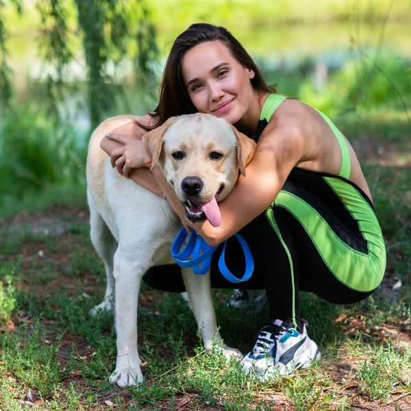 Fröhliche Hübsche Junge Frau Sitzt Und Umarmt Ihren Hund Flussufer — Stockfoto