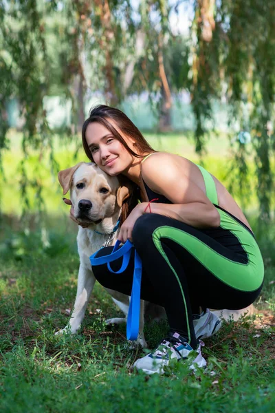 Fröhliche Hübsche Junge Frau Sitzt Und Umarmt Ihren Hund Flussufer — Stockfoto