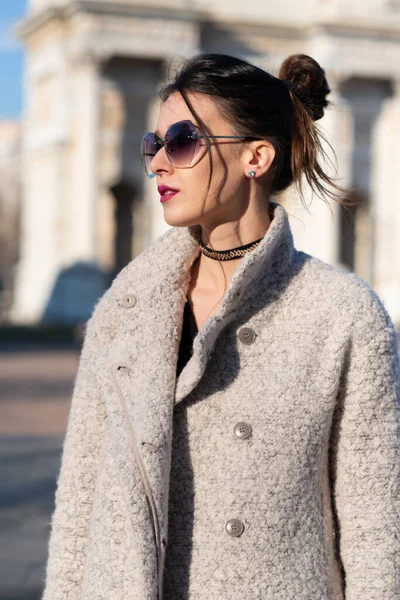 코트를 머리에 선글라스를 매력적 여성이 이탈리아 밀라노 거리의 야외에서 포즈를 — 스톡 사진