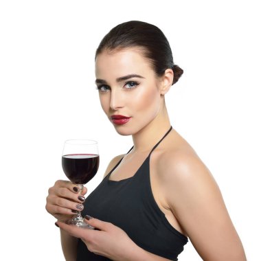 Elinde bir kadeh kırmızı şarap tutan genç ve çekici bir kadın. Güzel bayan alkollü içki içer. Beyaz arka planda izole edilmiş, siyah bir elbise ve bir kadeh şarap taşıyan güzel bir kız..