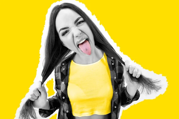 黄色い背景にピアスと舌を示すチェックシャツのヒップスターの女の子 不適切な行動だ ヒップスター 挑発だ 攻撃だ 正直さ ハイファッション — ストック写真