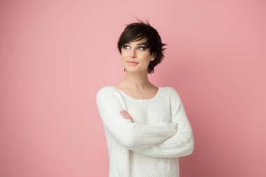 Stüdyoda pembe arka planda poz veren genç ve güzel bir bayan. Güzel esmer kadın portresi. Kız düşünür, hayal eder, gelecek için planlar yapar.
