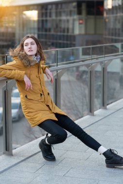 Manken dışarıda poz veriyor. Sarışın, Kafkasyalı bir kadın kış ayininde poz veriyor. Güzel kız, şehir portresi..