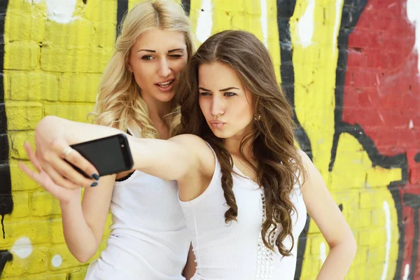 幸せな魅力的な女の子とともにスマートフォン取ります自殺に対してアーバンGrengge落書き壁 — ストック写真