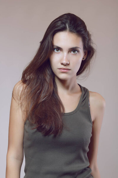 Fashion model. Young woman posing in studio. Beautiful caucasian girl over gray background, image toned. Female portrait