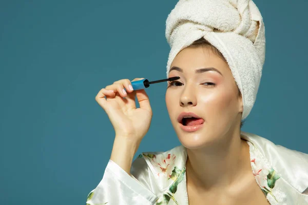 Jong Aantrekkelijk Vrouw Zetten Oog Mascara Blauwe Achtergrond Schoonheid Behandeling — Stockfoto