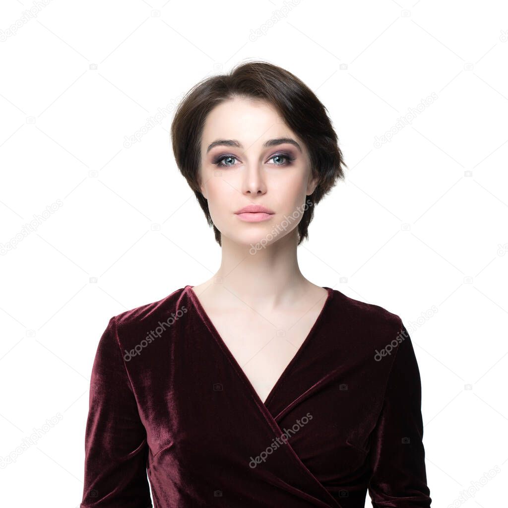 Beauty female portrait. Young attractive woman posing at studio over white background. Beautiful model with perfect make-up dressed evening burgundy dress looking at camera.