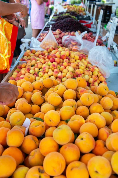 Fruit and vegetable market in Spain. Apples and peaches sold on outdoor market. Ripe spanish sesonal farm fruits for sale