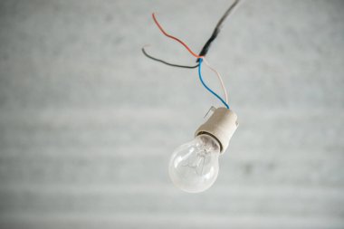 Parlayan lamba. Tavanda eski bir ampul var. Boş bir dairede biri tamirat yapıyor.