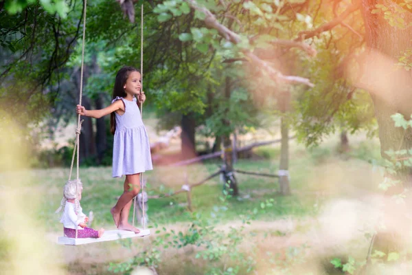 Fröhliches Mädchen Reitet Mit Ihrer Retro Puppe Auf Einer Seilschaukel — Stockfoto