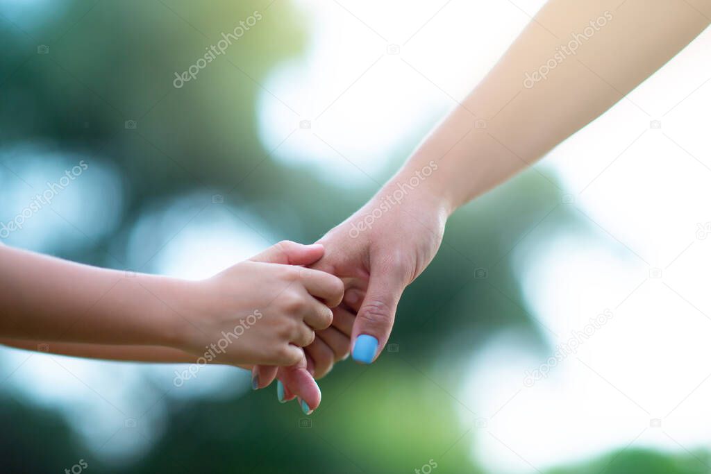 Woman's and kid's hands. Mother lead his child, summer nature outdoor. Parenting, togetherness, help, union, childhood, trust, family concept.