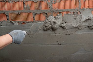 Duvara sıva yapan bir adam. İşçi tadilat yapıyor. İnşaat işleri, tamirat.. 