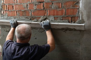 Duvara sıva yapan bir adam. İşçi tadilat yapıyor. İnşaat işleri, tamirat.. 