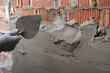 Duvara sıva yapan bir adam. İşçi tadilat yapıyor. İnşaat işleri, tamirat.. 