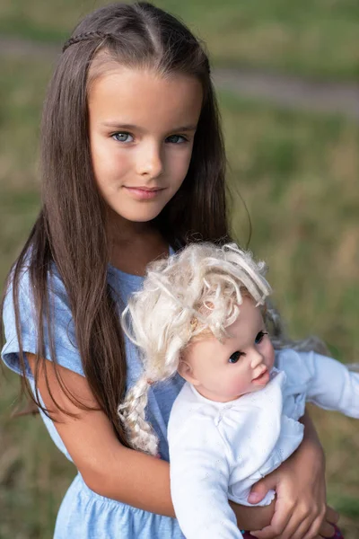 ヴィンテージ人形 夏の自然屋外で青いドレスに身を包んだかなり小さな女の子 子供の肖像画 美しい子供の穏やかな顔 — ストック写真