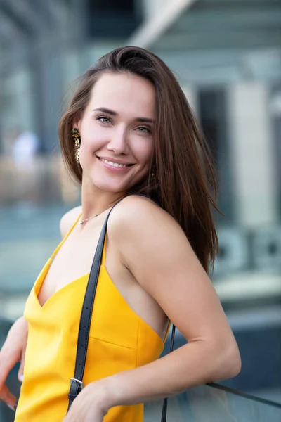 外でポーズをとるファッショナブルなかなりスタイリッシュな女の子 ストリートファッション 美しい若いブルネットの笑顔の女性は 市内中心部 夏の屋外で歩く黄色のドレスを着て — ストック写真
