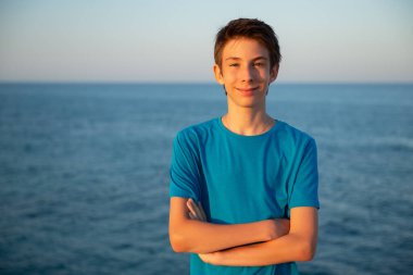 Plajdaki yakışıklı genç çocuk. Akdeniz kıyısında gülümseyen güzel bir genç çocuk. Seyahat, yaz tatili, turizm, gençlik yaşam tarzı.