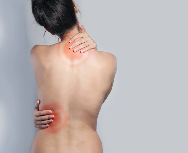Rückenschmerzen. Frau berührt ihren schmerzenden Rücken — Stockfoto