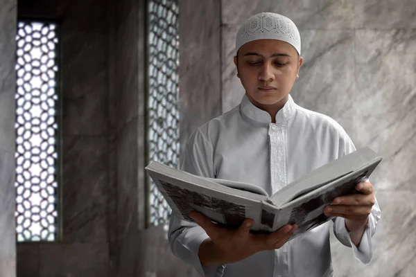 Мусульманин, читающий Коран в мечети — стоковое фото