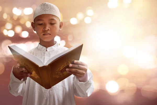 Азиатский ребёнок-мусульманин, читающий Коран — стоковое фото