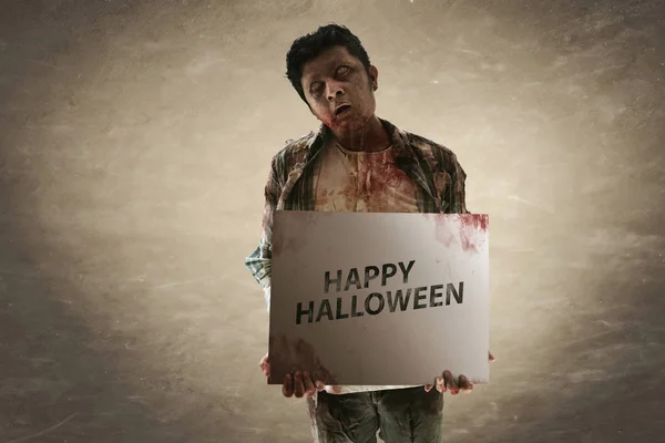 Zombie asustadizo sosteniendo papel de Halloween — Foto de Stock