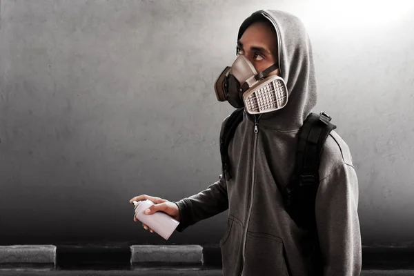 Graffiti artist wearing respirator mask