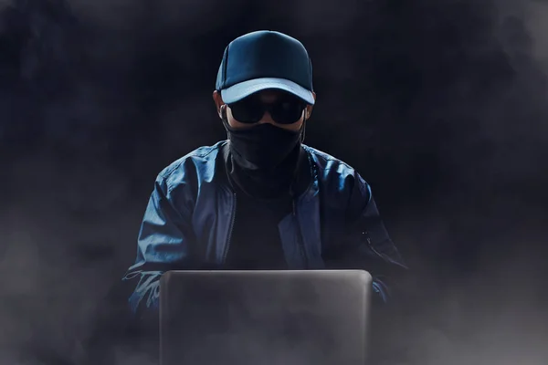 Desconocido hacker uso de ordenador portátil en la habitación oscura — Foto de Stock
