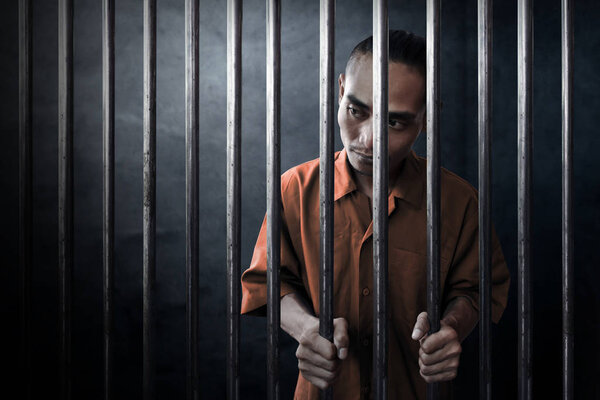 Asian man in dark prison