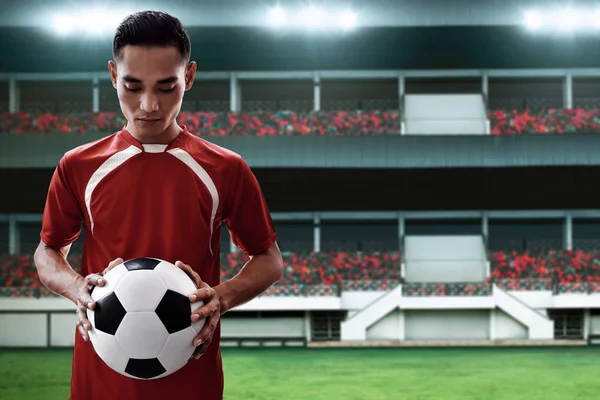 Soccer player holding soccer ball