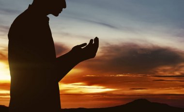 Müslüman adamın silueti dua ediyor.