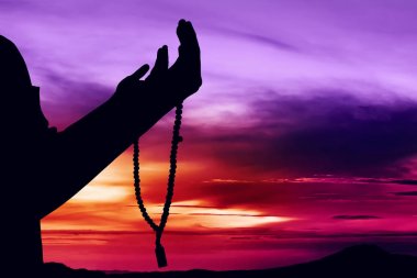 Müslüman adamın silueti dua ediyor.