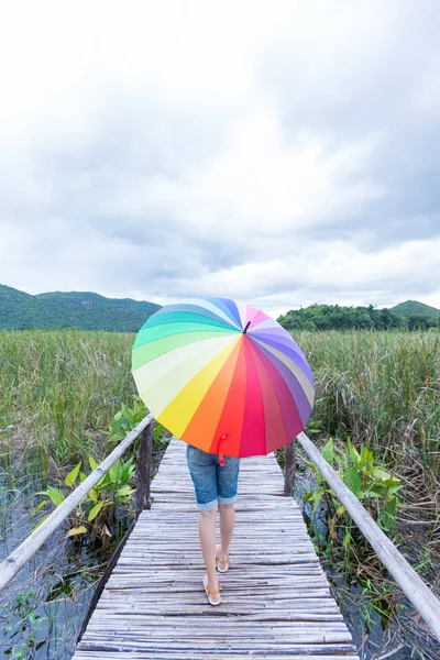 Mulher segurando um guarda-chuva na ponte . — Fotografia de Stock