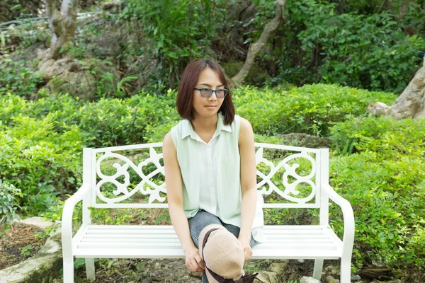 Frau mit Brille sitzt auf einem Stuhl — Stockfoto