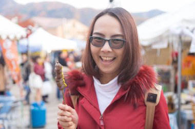 Gezgin Asyalı kadınlar Japonya'da dango yemekten zevk.