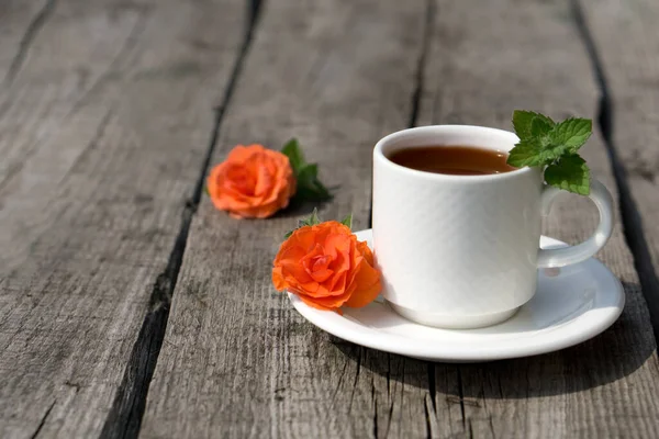 Flat lay Coffee composition  with  white cup    of coffe and  flower  and fresh leaf of mint on wooden rustic background