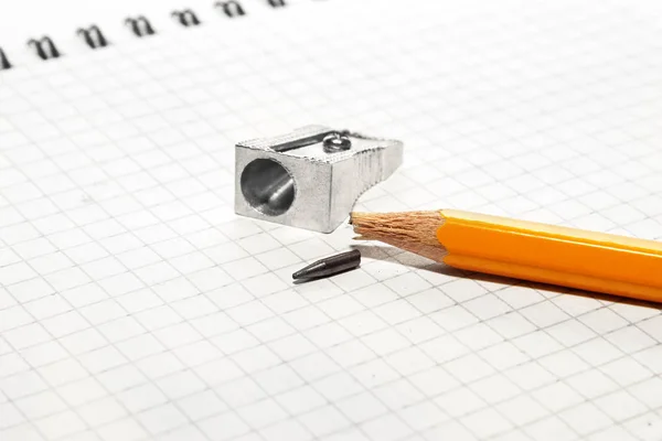 Kırık kalem ve kalemtıraş üzerinde bir not defteri — Stok fotoğraf