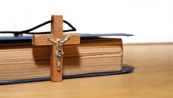 Livro e uma cruz de madeira — Fotografia de Stock