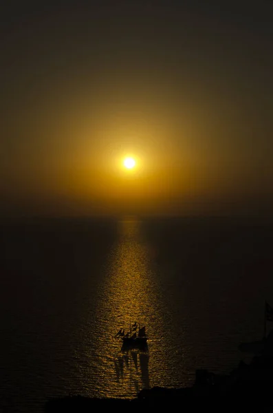 Santorini günbatımı bir yelkenli gemi ile