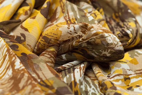 Pano claro marrom amarelo, tecido, têxtil com muitas dobras, tranças, vincos — Fotografia de Stock