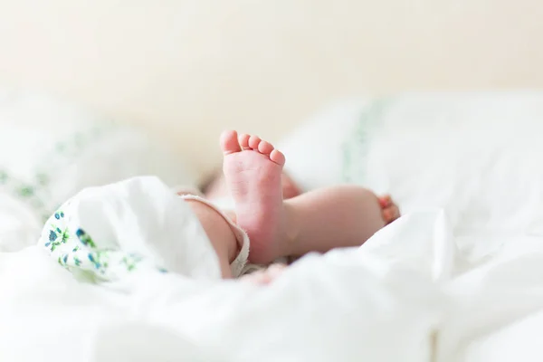 Babyfüße im weißen Bett — Stockfoto