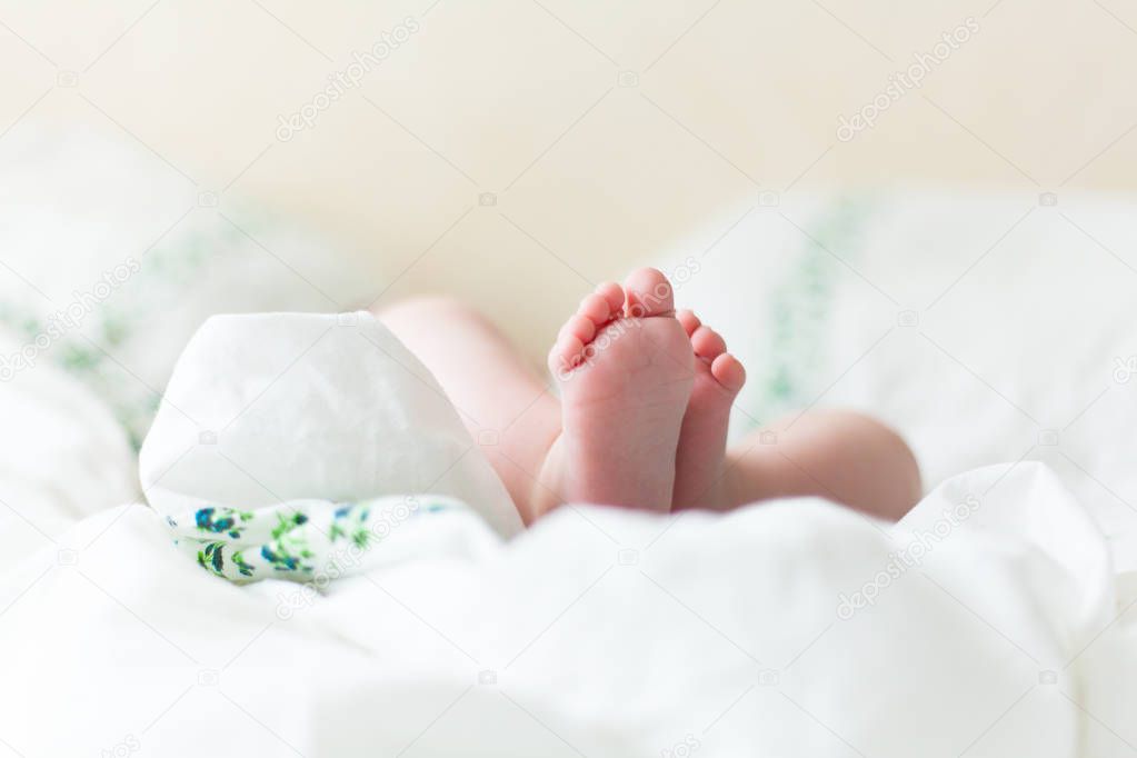 Baby feets in white bed