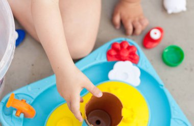 Çocuk eli renkli su oyunuyla oynuyor