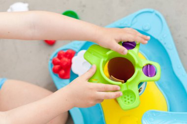 Çocuk eli renkli su oyunuyla oynuyor