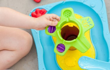 Çocuk eli renkli su oyunuyla oynuyor